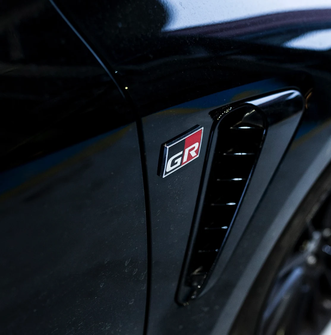 Detalle del emblema GR en un Toyota negro
